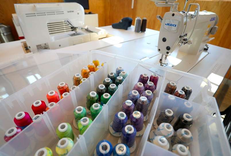 Spools of thread are sorted by color and stored in divided bins.
