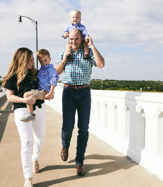 Mom and Dad with two young boys on the Walsh Ranch Parkway bridge.